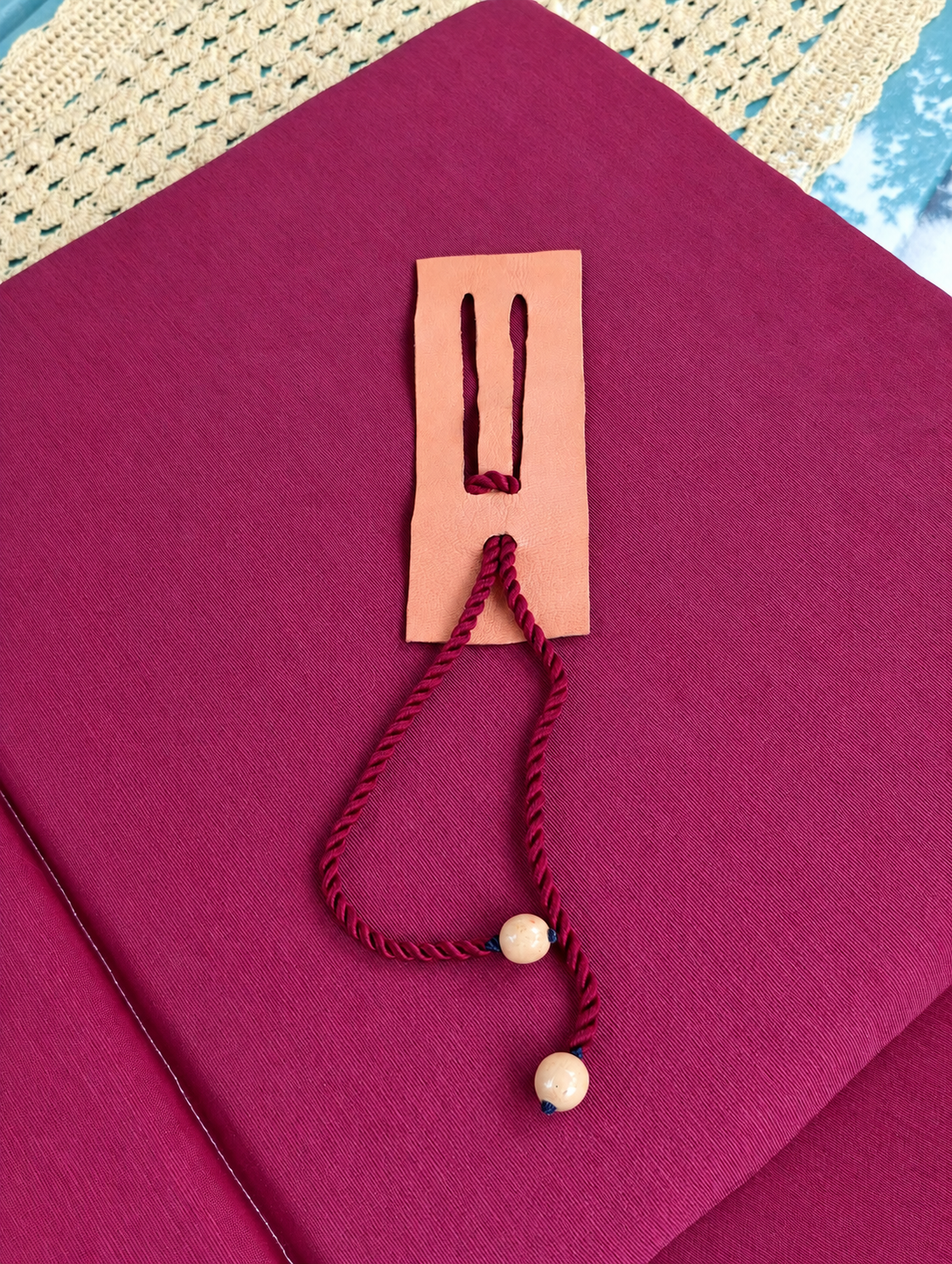 Reto de cuerda roja con dos cuentas de madera y una placa con ranuras